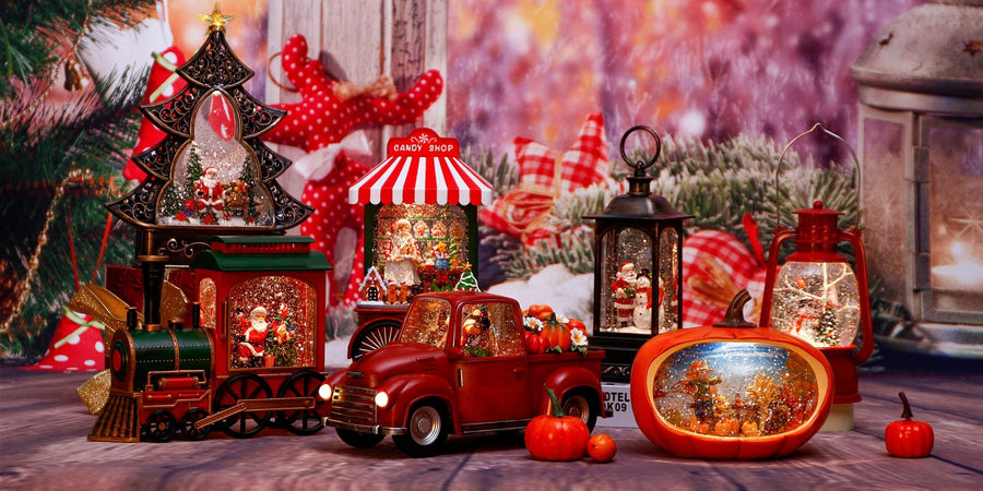 A row of lighted holiday snow globes, including a Christmas tree, a train, a red pickup truck and lanterns, on a wooden table